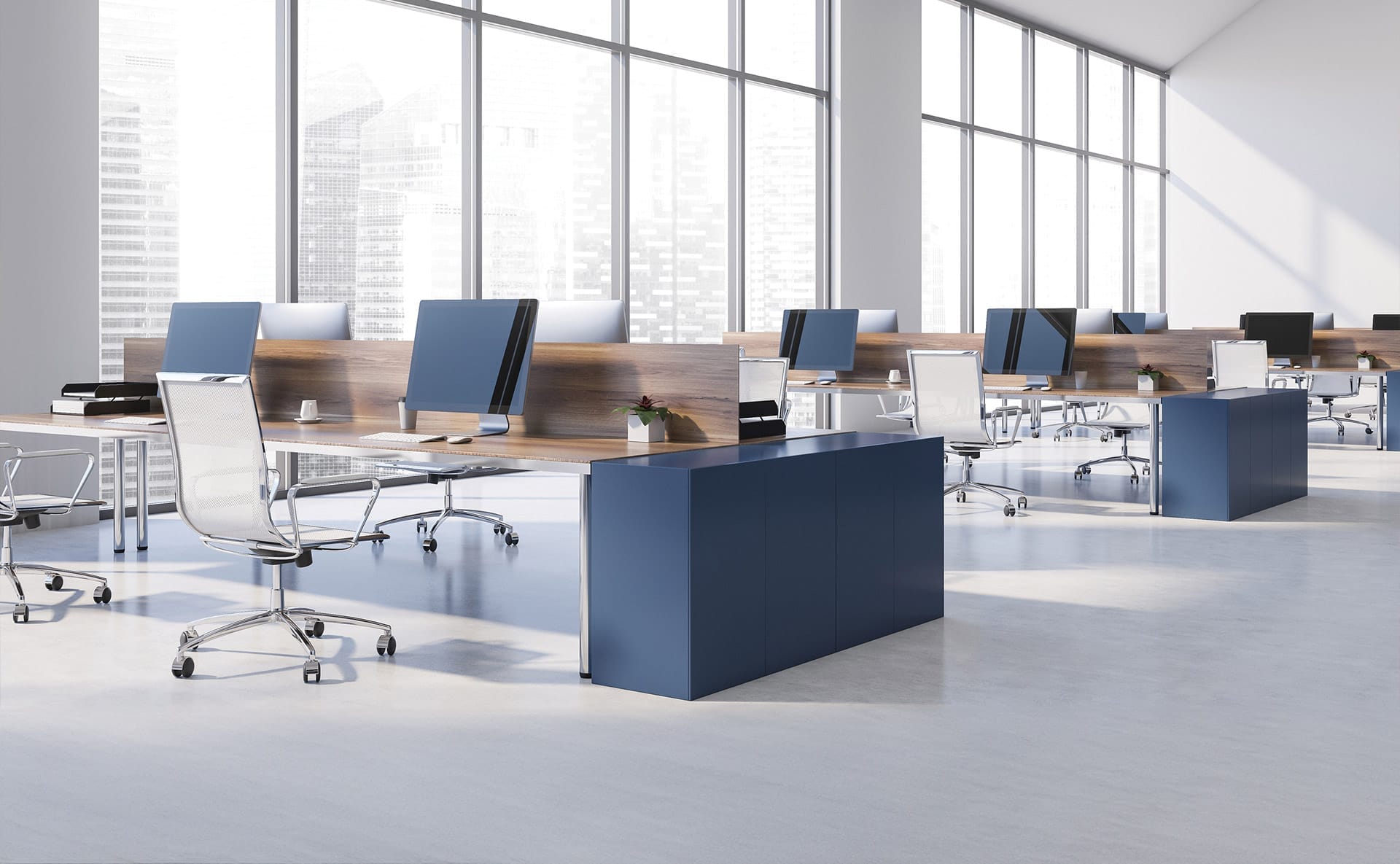 A large office with many desks, computer monitors and chairs