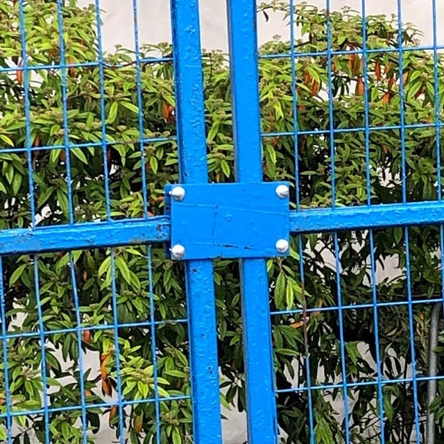 A blue security clamp for fences